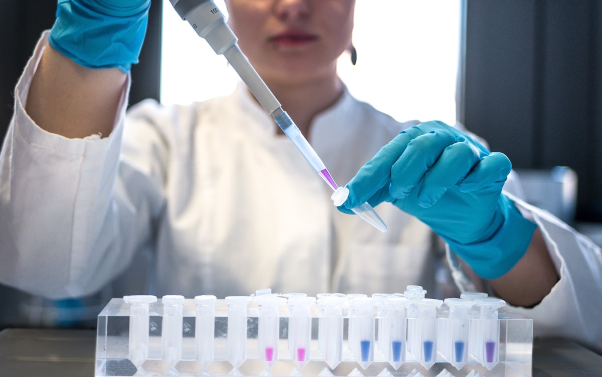 Scientist pipetting into a rack of sample tubes